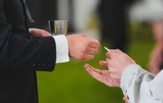 Pappi ojentamassa ehtoollisleipää.